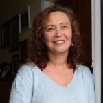 woman in blue top with shoulder length dark hair